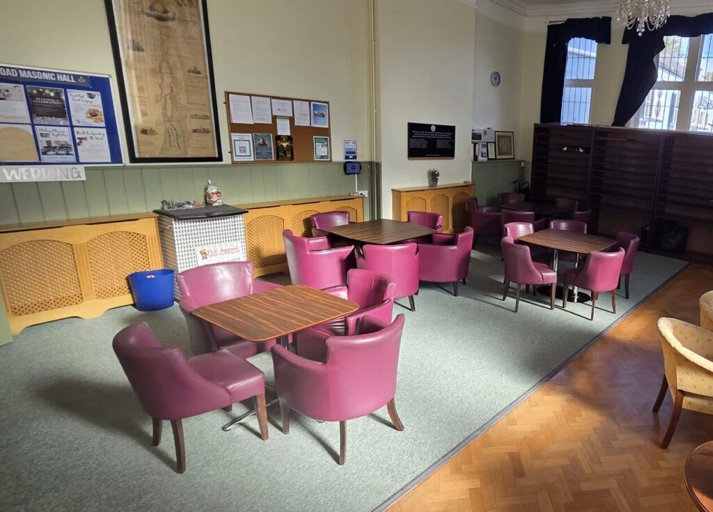 Comfortable bar lounge at Beverley Road Masonic Hall, with pink upholstered chairs arranged around tables.