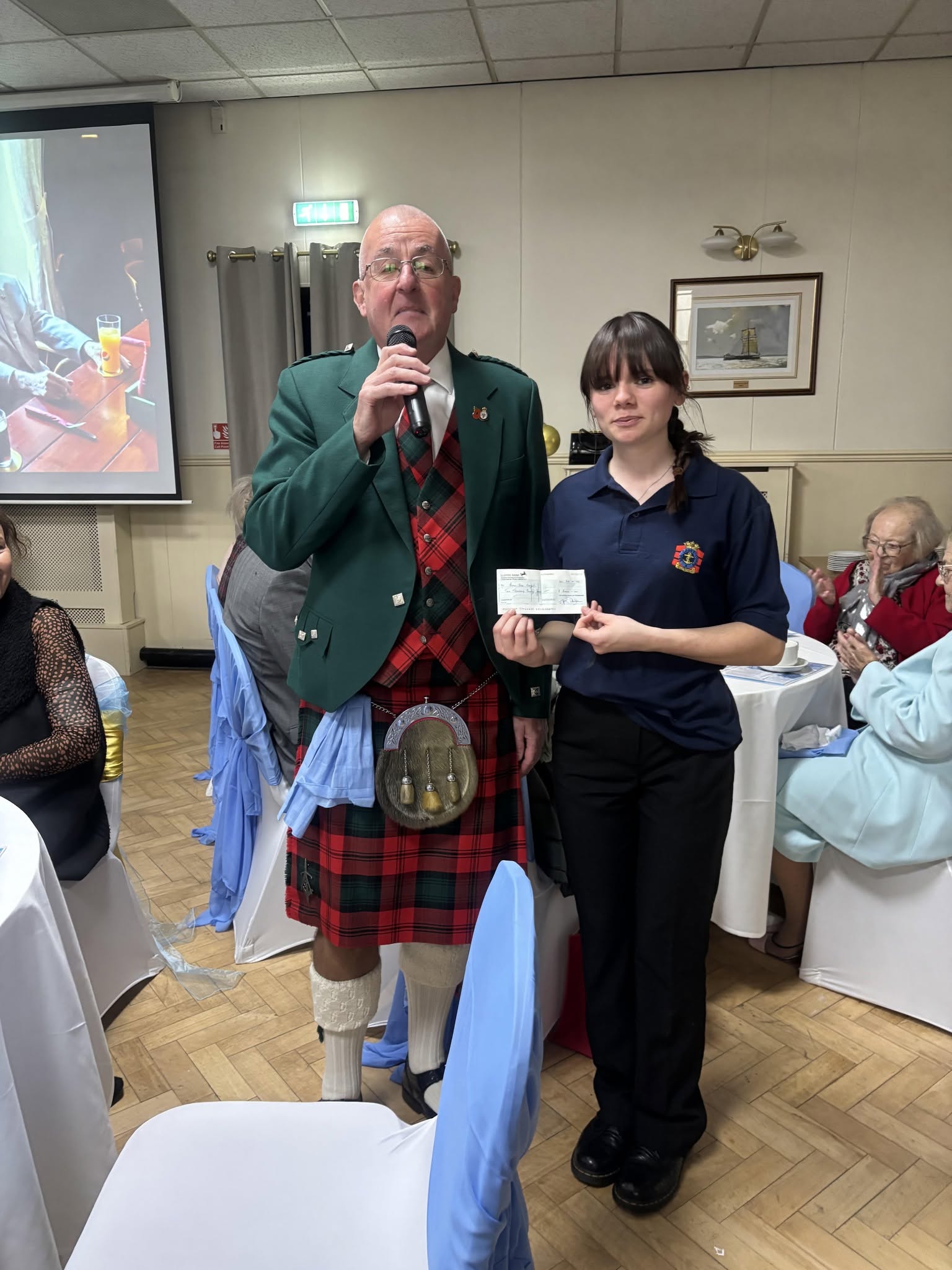 A Worshipful Master presenting a charitable donation cheque to Hull Cadets at Beverley Road Masonic Hall, supporting local young people.
